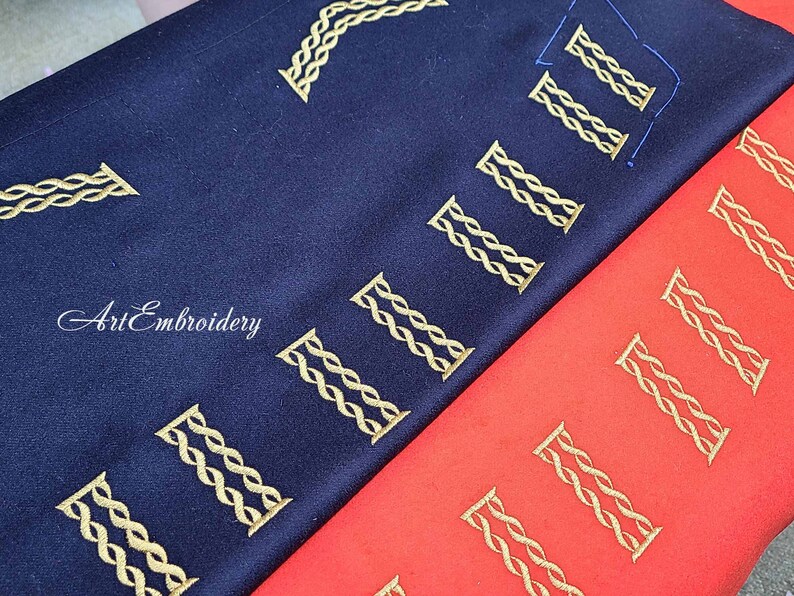 May include: Two fabric swatches with gold embroidery of the Roman numeral "II" repeated across the fabric. The top swatch is navy blue and the bottom swatch is red.