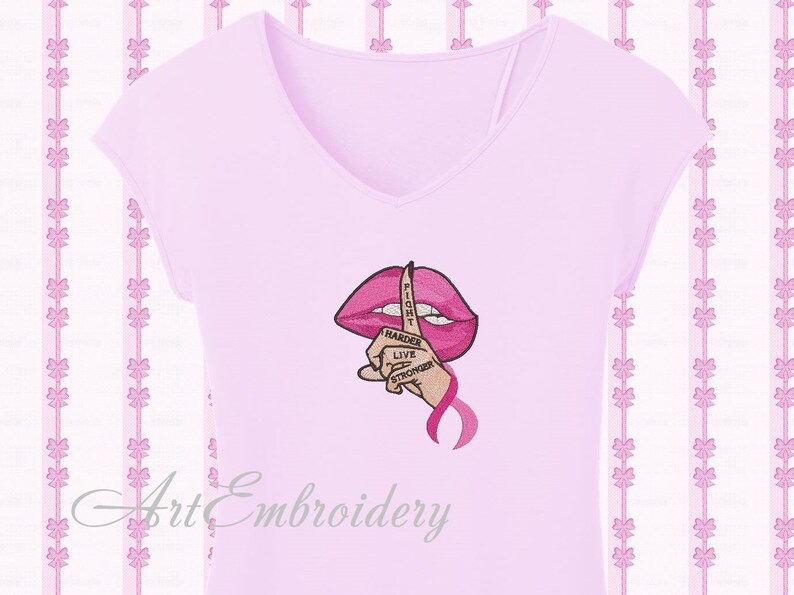 May include: Pink t-shirt with an embroidered design of a pink mouth with a finger over it. The finger has the words "Fight Harder Live Stronger" written on it. There is a pink ribbon below the finger.