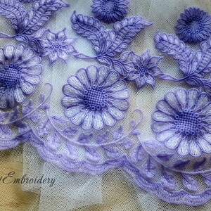 Puede incluir: Borde de encaje morado con bordado floral. El borde presenta hojas y flores delicadas con un centro blanco.