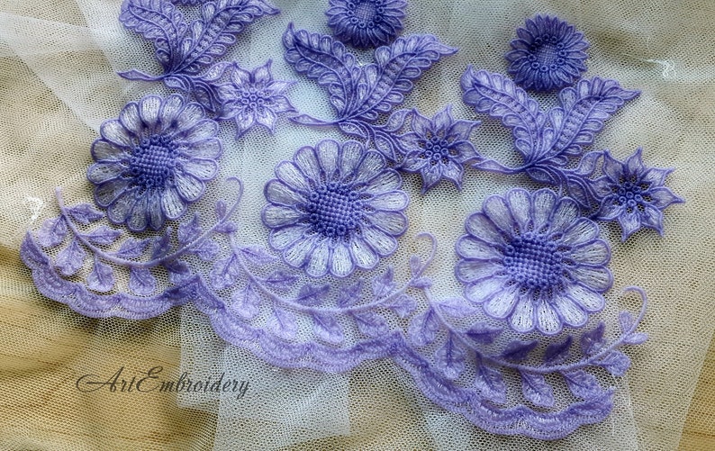 Puede incluir: Borde de encaje morado con bordado floral. El borde presenta hojas y flores delicadas con un centro blanco.