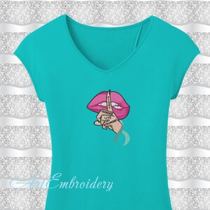 May include: A turquoise t-shirt with an embroidered design of a pink mouth with a finger over it. The finger has the words "Fight Harder Live Stronger" written on it.