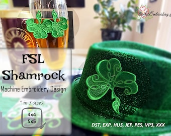 May include: Green shamrock machine embroidery design in three sizes: 4x4 and 5x5 inches. The design is shown on a green hat and a glass of beer. The text "FSL Shamrock Machine Embroidery Design" is also included.
