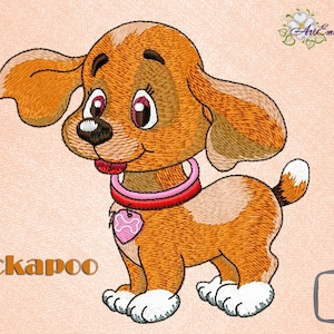 Op de afbeelding: Borduurontwerp van een bruine en witte Cockapoo-puppy met een roze halsband en een hartvormig label. Het ontwerp is verkrijgbaar in de maten 4x4 en 5x7 inch.