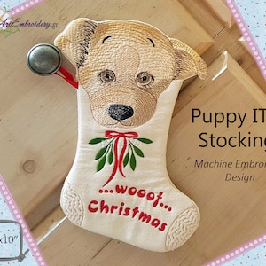 May include: A beige and white Christmas stocking with an embroidered puppy face, mistletoe, and the text "...wooof...Christmas".