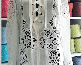 May include: White lace blouse with a lace-up neckline and intricate floral designs. The blouse has long sleeves and a relaxed fit. The text "Art Embroidery" is visible at the bottom of the blouse.