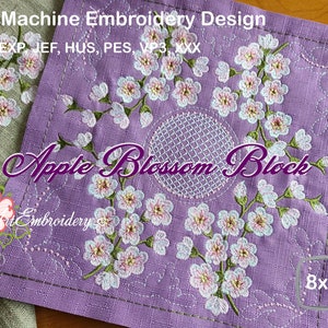 Pode incluir: Tecido roxo com um desenho bordado de flores de macieira e um círculo de malha. O tecido mede 8x8 polegadas e o texto "ITH Machine Embroidery Design" e "Apple Blossom Block" é visível.