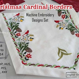 May include: White fabric with embroidered Christmas cardinal and border designs. The design includes red cardinals, pinecones, poinsettias, and green foliage. The text "Christmas Cardinal, Borders" and "Machine Embroidery Designs Set" are visible.