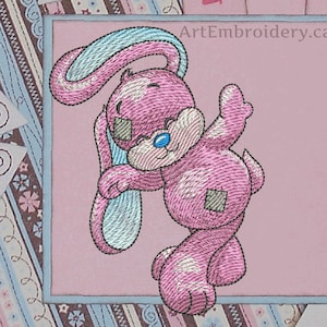 May include: Pink embroidered bunny with blue ears holding a blue and white striped object. The bunny has a patch on its belly and a blue nose. The background is pink with a white border.