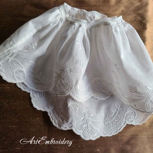 Puede incluir: Borde de encaje de algodón blanco con delicado bordado floral. El encaje es festoneado y tiene un borde fruncido. El bordado está hecho con un hilo blanco delicado.