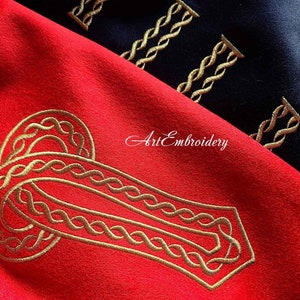 May include: Gold embroidery design of a Celtic knot on a red fabric background. The design is intricate and detailed, with a repeating pattern of interlacing loops.