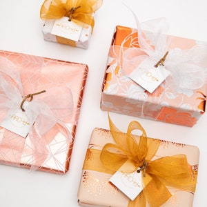pink and copper gift wrap with gold and white ribbon