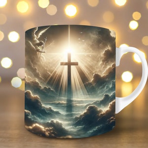 May include: White ceramic mug with a graphic of a cross in the clouds with a bright light shining down. The cross is surrounded by clouds and a figure of an angel with wings.