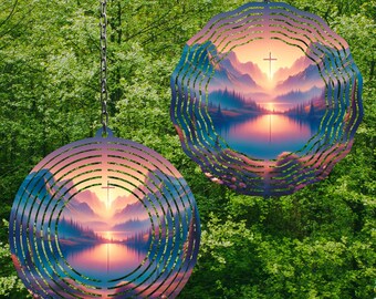 May include: Two metal wind spinners with a circular design. Each spinner features a colorful image of a mountain lake with a cross at the top of a mountain. The spinners are suspended from chains.