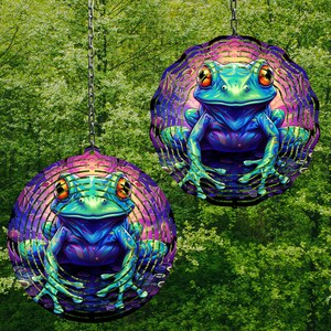 May include: Two metal wind spinners with a colorful frog design. The frogs are blue, green, and purple with black eyes. The spinners are suspended from a chain.