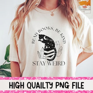 May include: A white t-shirt with a black cat illustration and the text "Read Books, Be Kind, Stay Weird".