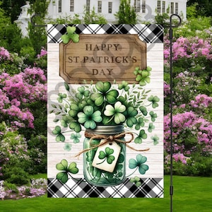 May include: A black and white checkered garden flag with a wooden sign that says "Happy St. Patrick's Day". A mason jar filled with green shamrocks is in front of the sign.