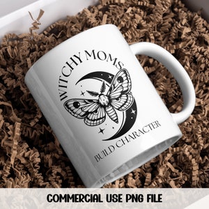 K&ouml;nnte beinhalten: Eine wei&szlig;e Keramiktasse mit einer schwarz-wei&szlig;en Grafik eines Nachtfalters und eines Halbmondes. Der Text "Witchy Moms Build Character" ist auf die Tasse gedruckt.