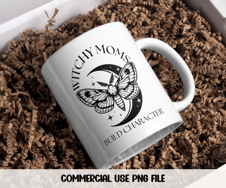 K&ouml;nnte beinhalten: Eine wei&szlig;e Keramiktasse mit einer schwarz-wei&szlig;en Grafik eines Nachtfalters und eines Halbmondes. Der Text "Witchy Moms Build Character" ist auf die Tasse gedruckt.
