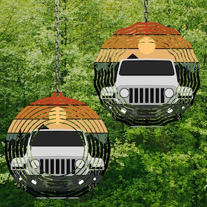 Puede incluir: Dos carillones redondos y coloridos con un diseño de silueta de jeep. Los carillones tienen una escena de puesta de sol y montaña con un jeep blanco en el centro. Los carillones están colgados de una rama de árbol.