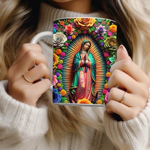 May include: White ceramic mug featuring a vibrant illustration of a religious figure surrounded by colorful flowers. The artwork includes a halo and a radiant background, with a variety of floral elements in shades of red, pink, orange, and purple.