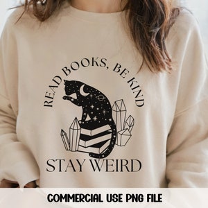 May include: A beige sweatshirt with a black graphic design featuring a cat sitting on a stack of books. The text reads "Read Books, Be Kind, Stay Weird".
