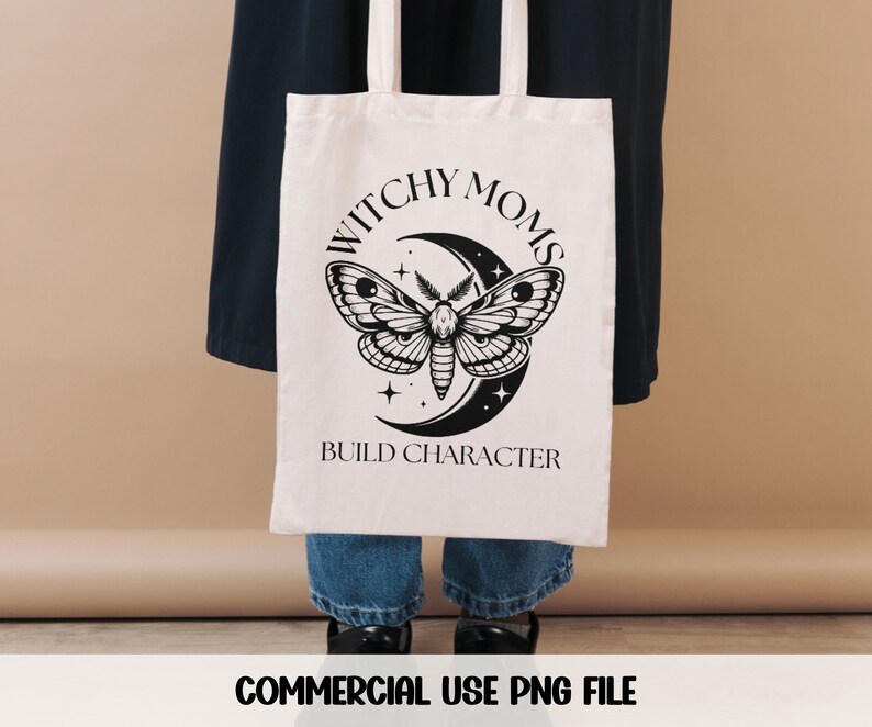 K&ouml;nnte beinhalten: Eine wei&szlig;e Einkaufstasche mit dem Aufdruck "Witchy Moms Build Character". Das Design zeigt einen schwarz-wei&szlig;en Schmetterling mit einer Mondsichel und Sternen.