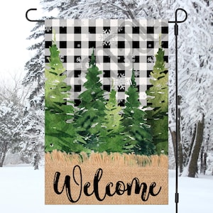 May include: A welcome sign with a black and white buffalo check pattern and a burlap background. The sign features a watercolour illustration of green pine trees and the word "Welcome" in black text.