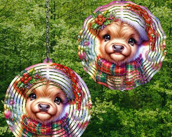 May include: Two metal wind spinners with a circular design. Each spinner features a cute cartoon Highland cow wearing a Santa hat and a plaid scarf. The spinners are suspended from chains.