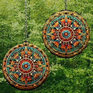 Puede incluir: Dos colgantes de pared redondos y decorativos con intrincados patrones geométricos en tonos azules, naranjas y marrones. Los patrones se asemejan a un diseño de brújula o estallido de estrellas. Los colgantes están suspendidos del techo por cadenas.