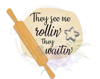 May include: A brown wooden rolling pin with a white background and the text "They see me rollin' they waitin'" in black. A silver star-shaped cookie cutter is on the right side of the text.