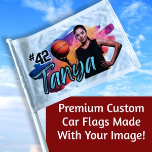 May include: White car flag featuring a basketball player holding a basketball. The flag has the name "Tanya" and the number "42" printed on it. The background is a colorful splash of paint. The flag is attached to a white pole.
