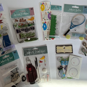 May include: A collection of golf-themed embellishments and stickers, including golf bags, clubs, golf balls, flags, and a golf cart. Some packages feature the text "In the Rough" and "Birdie". Other packages include tennis rackets and balls.