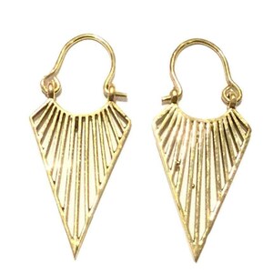 May include: A pair of gold-toned triangle shaped earrings with a geometric design. The earrings have a hoop design at the top.
