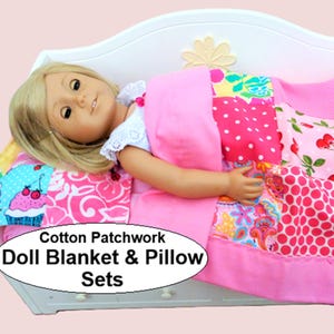 May include: A doll with blonde hair lies in a white bed under a colorful patchwork blanket featuring pink, red, and white patterns including cherries, polka dots, and cupcakes. The text Cotton Patchwork Doll Blanket & Pillow Sets is visible.