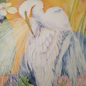 May include: Watercolor painting of a white egret preening its feathers. The bird is set against a backdrop of an orange sun, with green foliage and pink lotus flowers in the foreground. The artwork has a soft, ethereal quality.