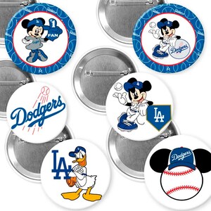 May include: A collection of round pinback buttons featuring the Los Angeles Dodgers baseball team and Disney characters. Designs include Mickey Mouse, Donald Duck, and the Dodgers logo in blue, white, and red.