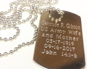 May include: A silver dog tag necklace with a chain. The dog tag is engraved with the text "Gertrude R. Gibson US Army Wife and Mother 05-17-1919 09-16-2017 John 14:1-6".
