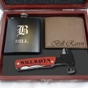 Può includere: Una scatola regalo in legno con una fiaschetta nera incisa con la lettera "B" e il nome "BILL", un portafoglio in pelle marrone inciso con il nome "Bill Raven", e un martello multifunzione inciso con il nome "WILL RAVEN".