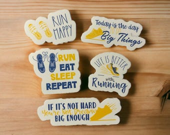 Puede incluir: Cinco pegatinas motivacionales con temática de running con acentos amarillos y azules. Las pegatinas presentan textos como "Run Happy", "Run Eat Sleep Repeat", "Today is the day to do Big Things", "Life is Better with Running", y "If it's not hard you're not dreaming big enough".