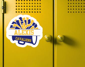 Peut inclure: Un casier jaune avec un autocollant portant le nom "ALEXIS" et le mot "CAVALIERS" en bleu et or. L'autocollant présente un design de mégaphone et un graphique de pompons. Le casier a deux portes avec des boutons ronds et des trous de ventilation.