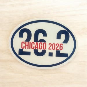 Puede incluir: Una pegatina ovalada con el texto "26.2 CHICAGO 2026". Los n&uacute;meros "26.2" son de color azul marino, con "CHICAGO 2026" en rojo. La pegatina tiene un fondo blanco y un borde azul marino. Ideal para corredores de marat&oacute;n.