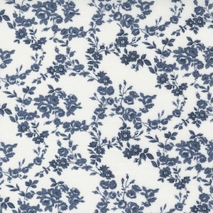 May include: White fabric featuring a repeating pattern of blue floral bouquets and vines. The flowers are detailed with multiple petals and leaves, creating a classic design. Suitable for sewing and crafting projects. The pattern is reminiscent of vintage textiles.