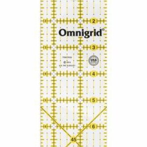 Pode incluir: Uma régua de quilting retangular transparente Omnigrid com linhas de grade amarelas, marcações de medição pretas e números de 1 a 7 polegadas. A ferramenta inclui uma linha de ângulo de 45 graus, um orifício circular e o texto USA.