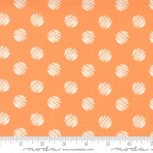 Peut inclure: Tissu orange à pois blancs. Les pois sont dessinés avec un motif de lignes griffonnées. Le tissu est marqué "moda" et une adresse de site web.