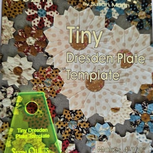 以下が含まれることがあります： Suzn QuiltsのTiny Dresden Plate Templateとラベル付けされたネオンイエローのアクリル製キルティングテンプレート。様々な布製の花のデザインとMakes 4-1/2 inch Finished Blockというテキストが印刷されたパターンカバーの上に配置されています。