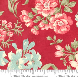 May include: Red fabric with a floral pattern featuring pink and white flowers with green leaves. The fabric has a white ruler with the word "moda" printed on it.