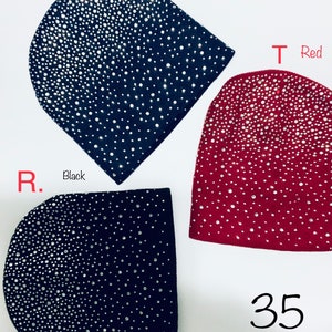 Pode incluir: Três chapéus de malha com strass. Os chapéus são azul marinho, preto e vermelho. O texto "S. Navy", "R. Black" e "T Red" está escrito nos chapéus. O texto "Sparkles on front only, back is flat and smooth!" está escrito acima dos chapéus. O número "35" está escrito abaixo dos chapéus.