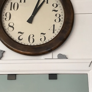 May include: A brown wooden clock with white face and black numbers. Three small gray mice are attached to the wall around the clock.