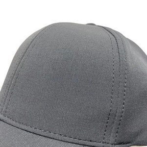 May include: A black baseball cap with a structured crown and a curved brim. The cap has a subtle texture and is made of a durable fabric.