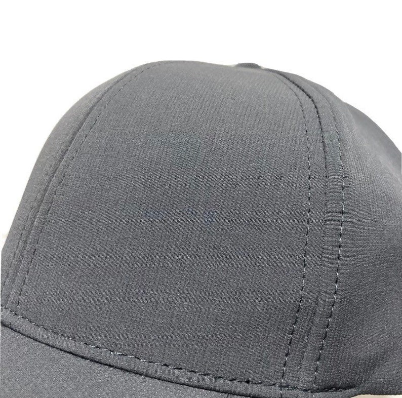 May include: A black baseball cap with a structured crown and a curved brim. The cap has a subtle texture and is made of a durable fabric.